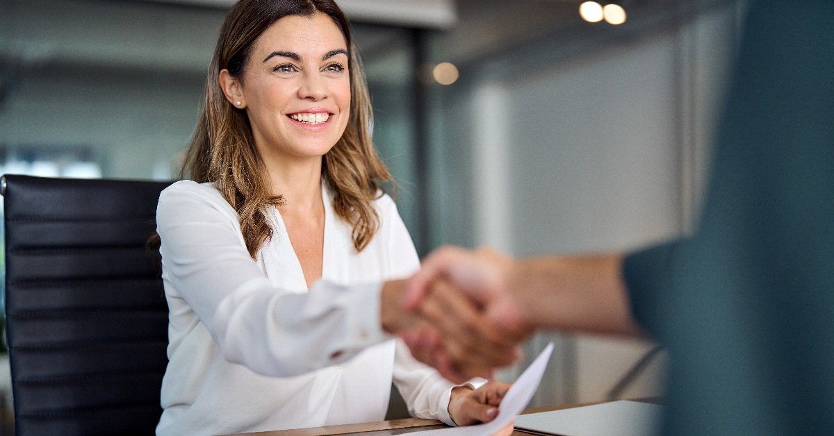 Female manager shakes hands after contract agreement.