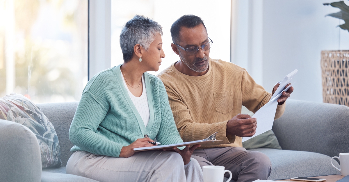 senior couple on sofa with bills