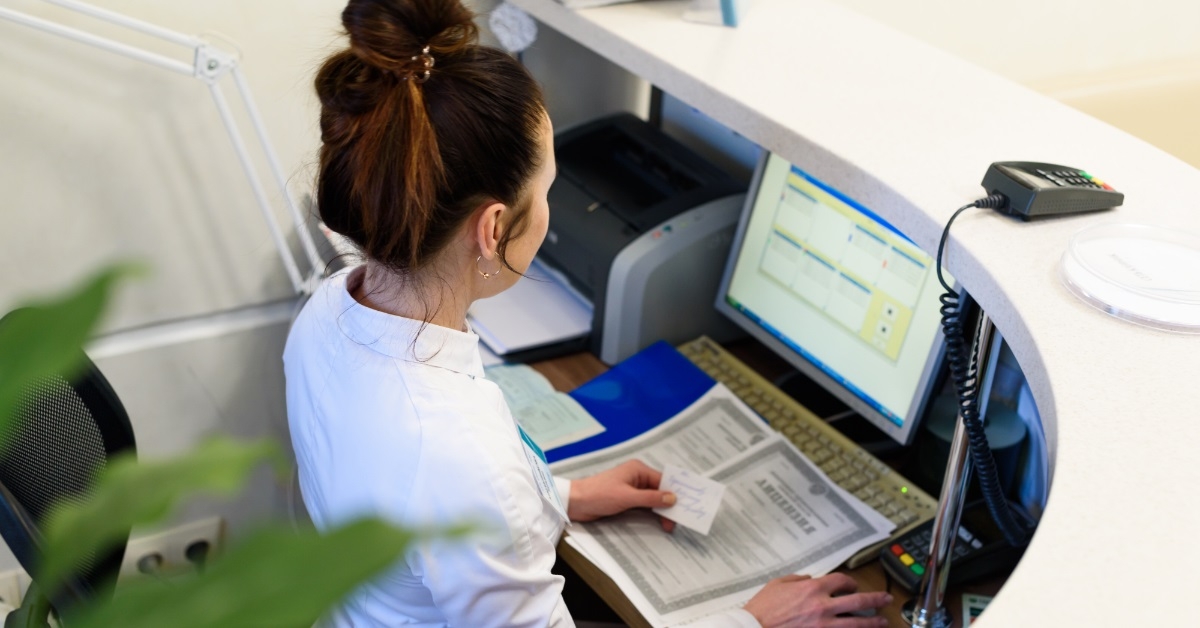 female receptionist using computer at hospital