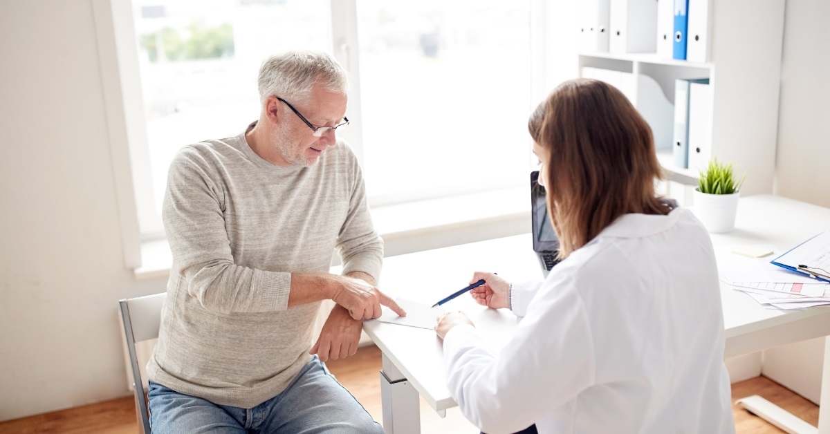 senior man with doctor discussing prescription