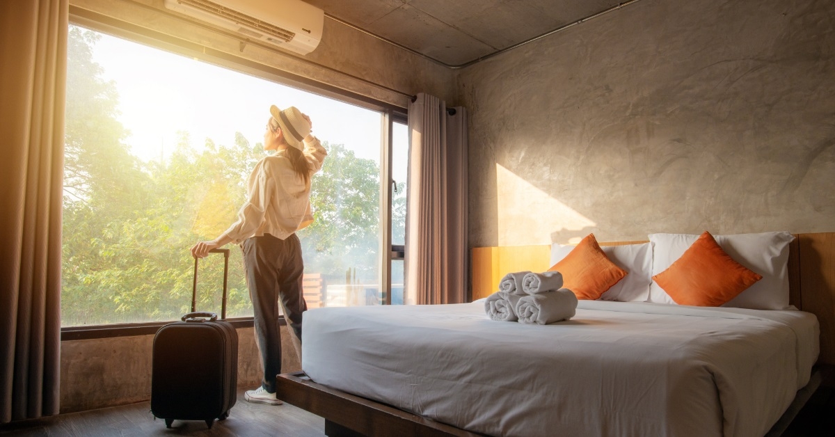 woman exploring hotel room with luggage