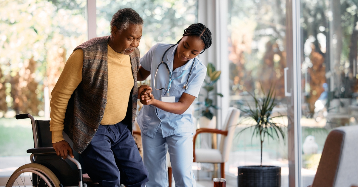 black nurse assists senior man