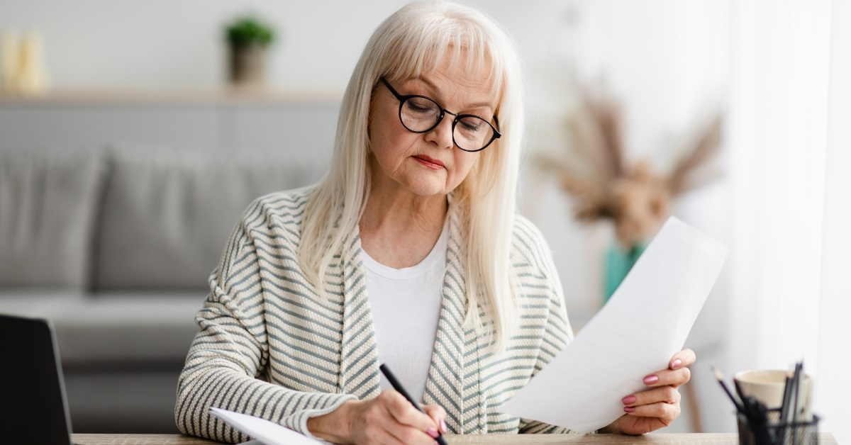 senior woman reviewing bills at home