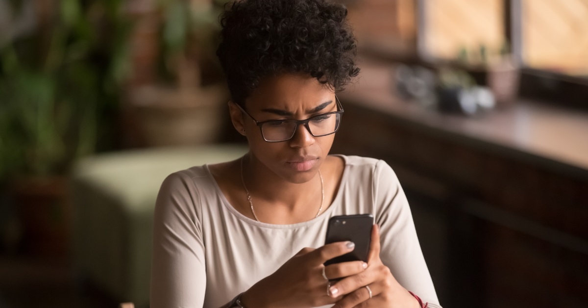 stressed african american woman using smartphone