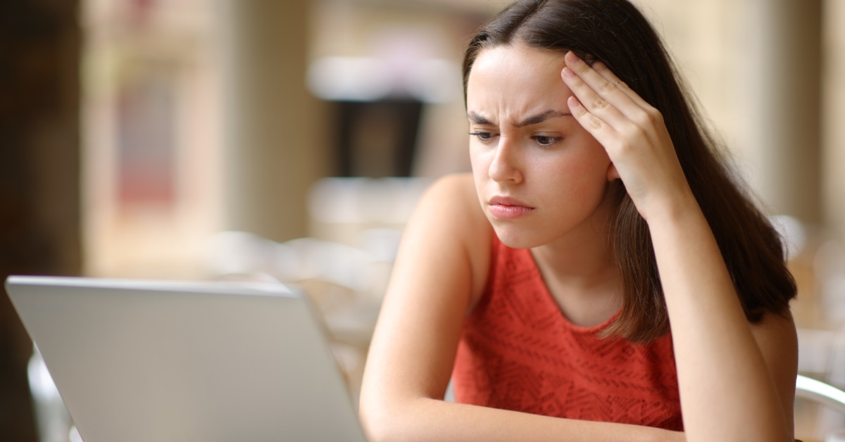 worried woman using laptop at restaurant