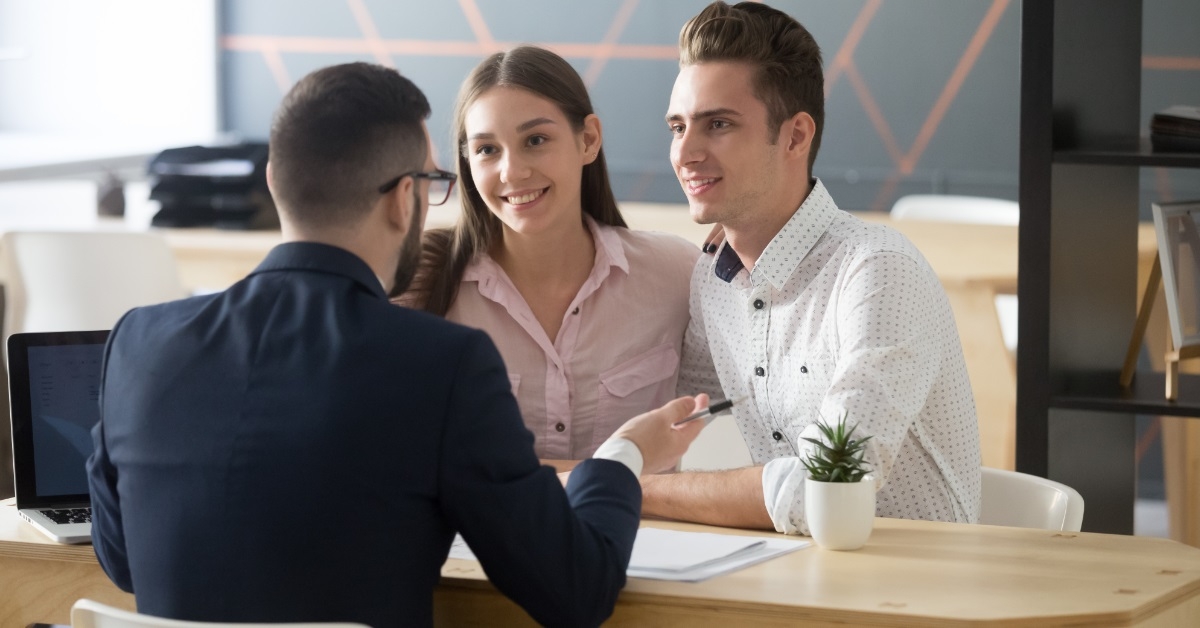 young couple consulting male finance advisor