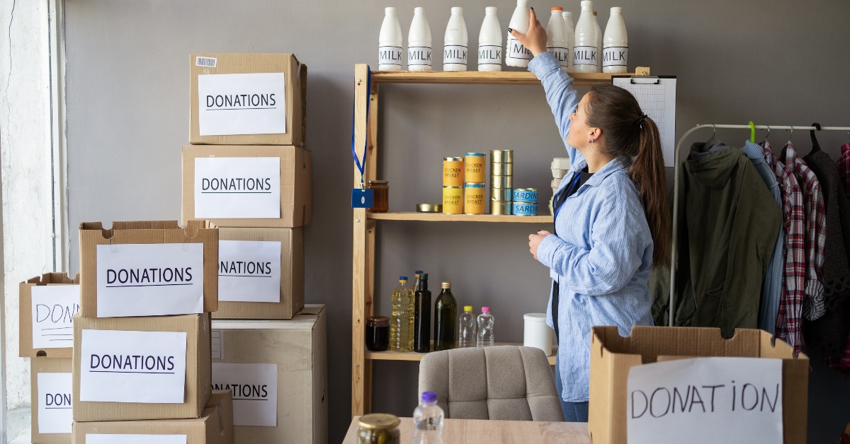 female volunteer preparing food donation boxes