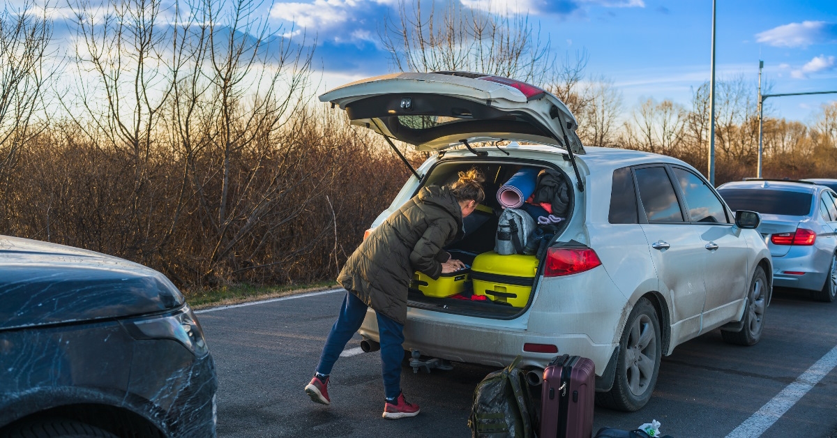 ukrainian refugee packing luggage in trunk