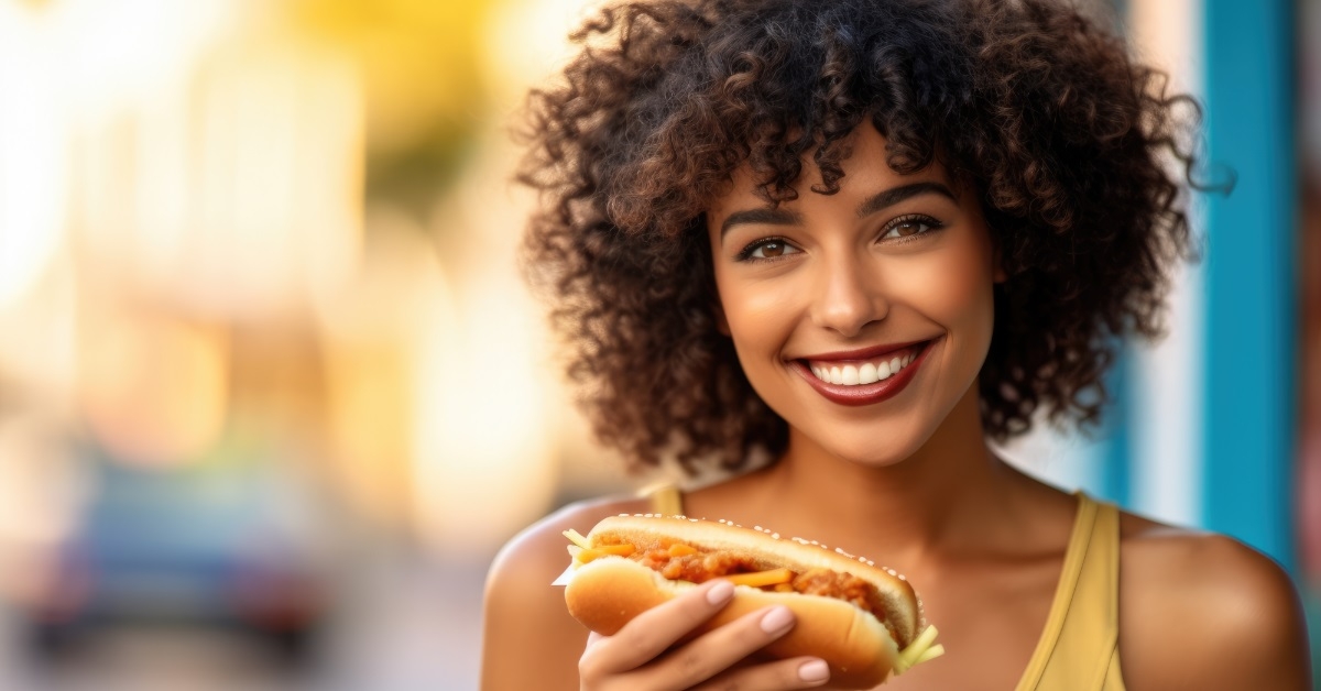 african american woman holding hot dog