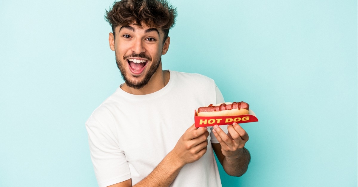excited man holding hot dog