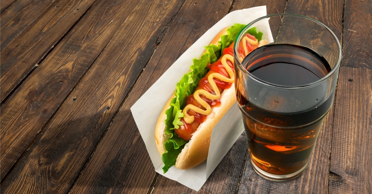 drink and hot dog on table