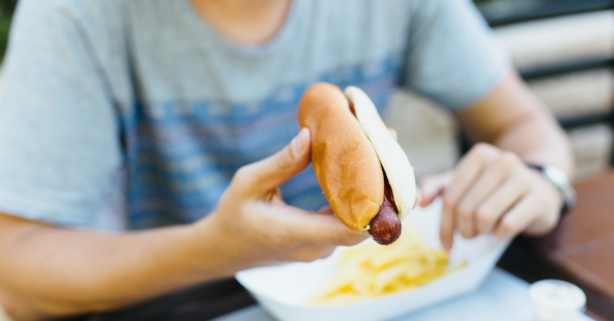 man eating hot dog in cafe
