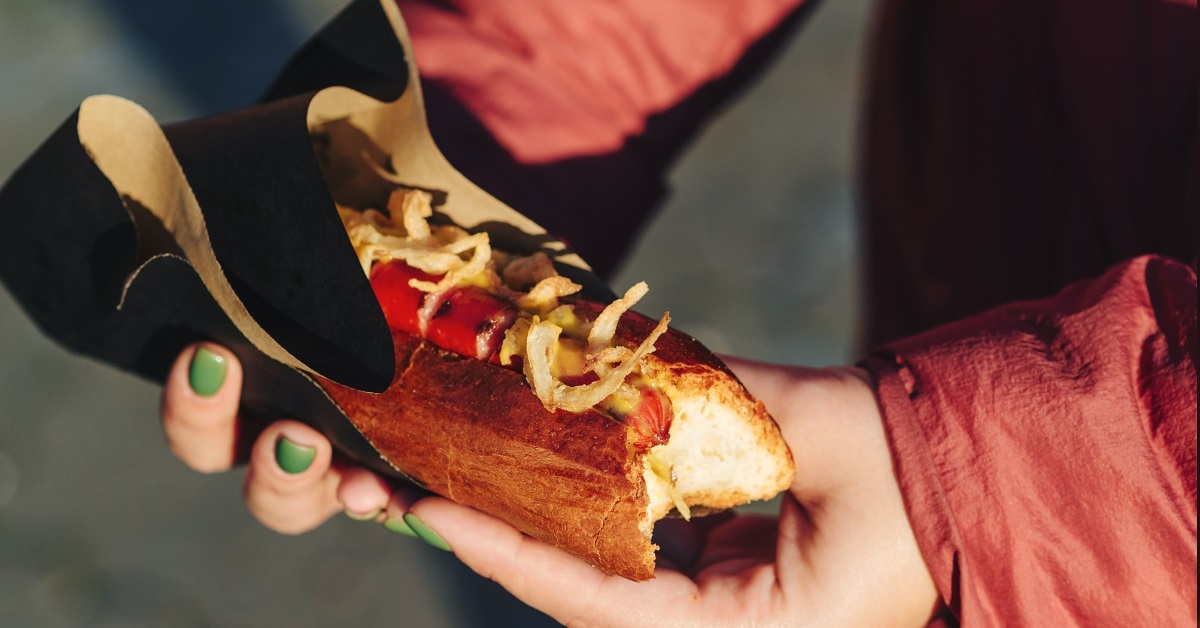 woman holding grilled hot dog 