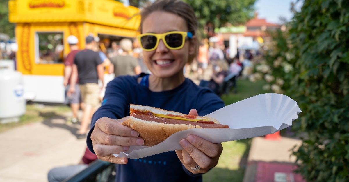 woman holding hot dog at fair