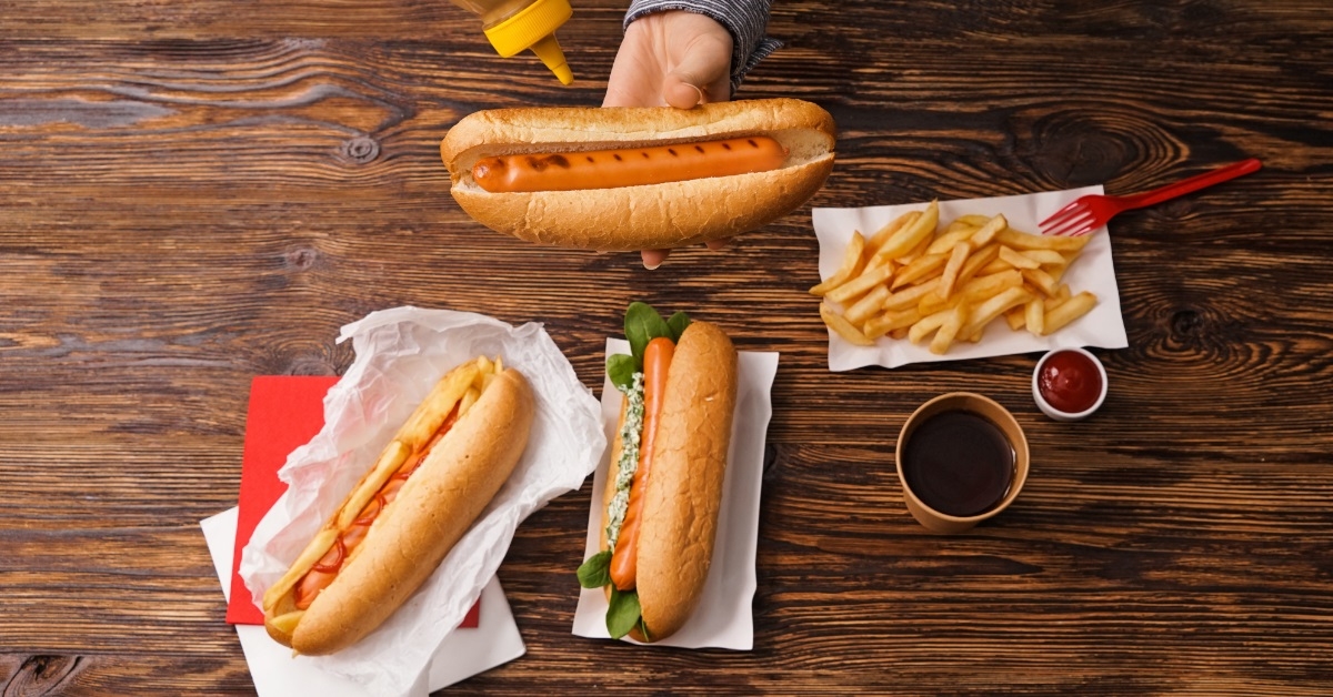 woman preparing hot dog at table
