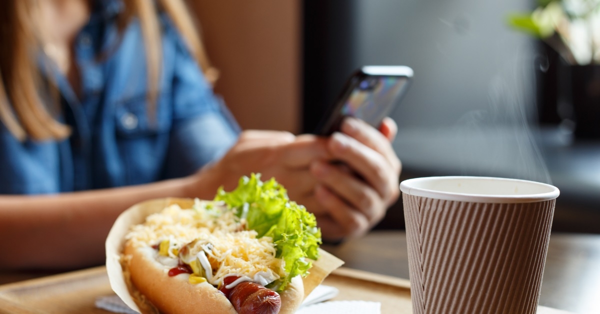 woman with hotdog on table