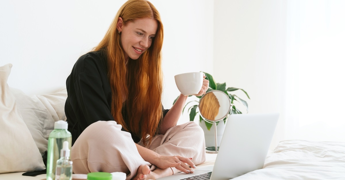 woman using laptop while having coffee