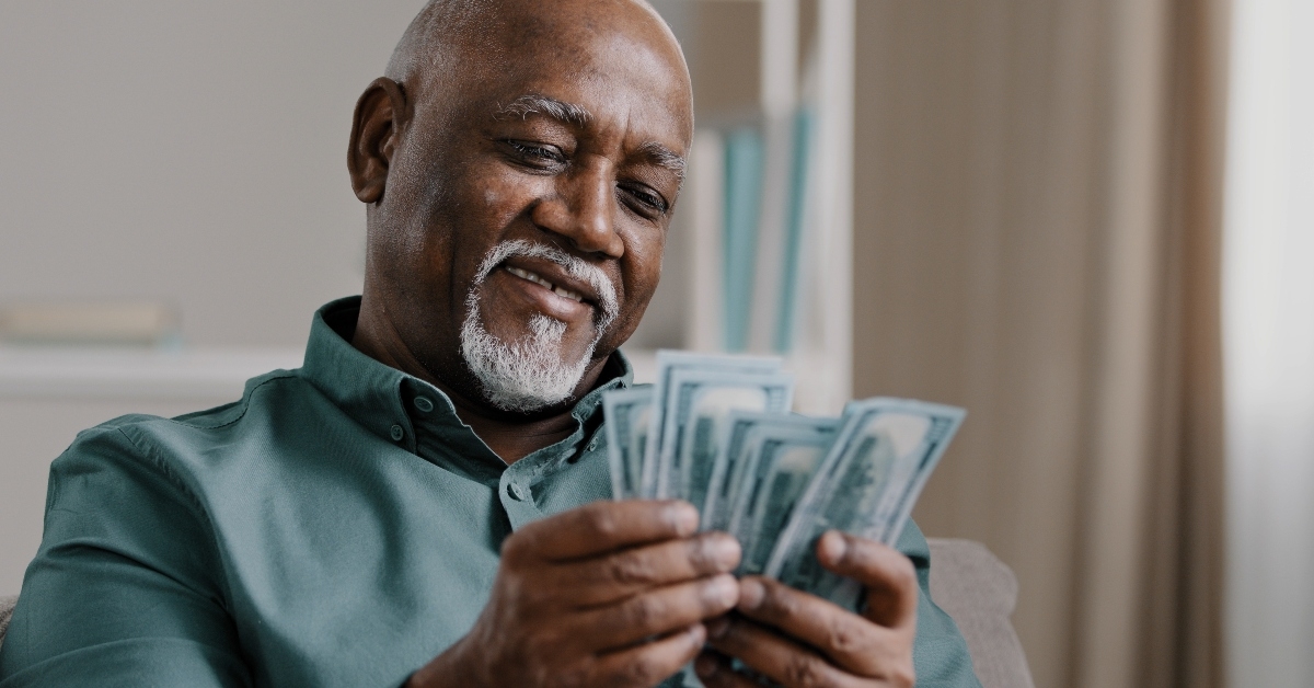 mature male with pile of dollars