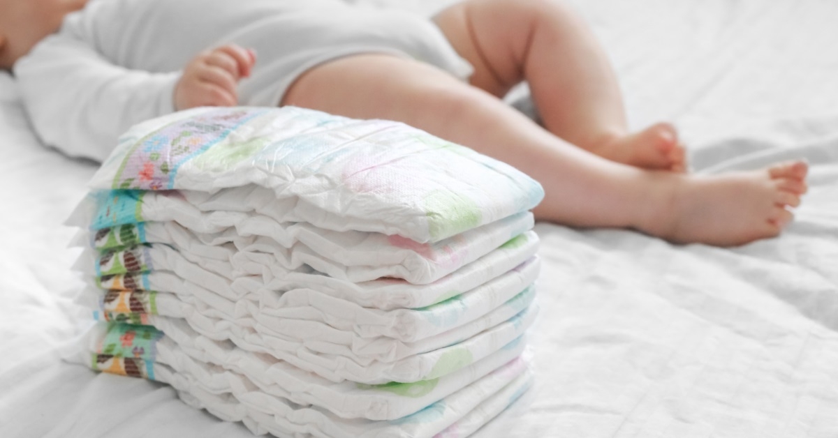 diapers besides baby in white sheets