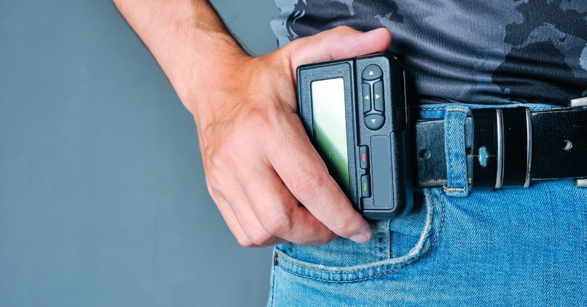 hand holding pager on denim jeans