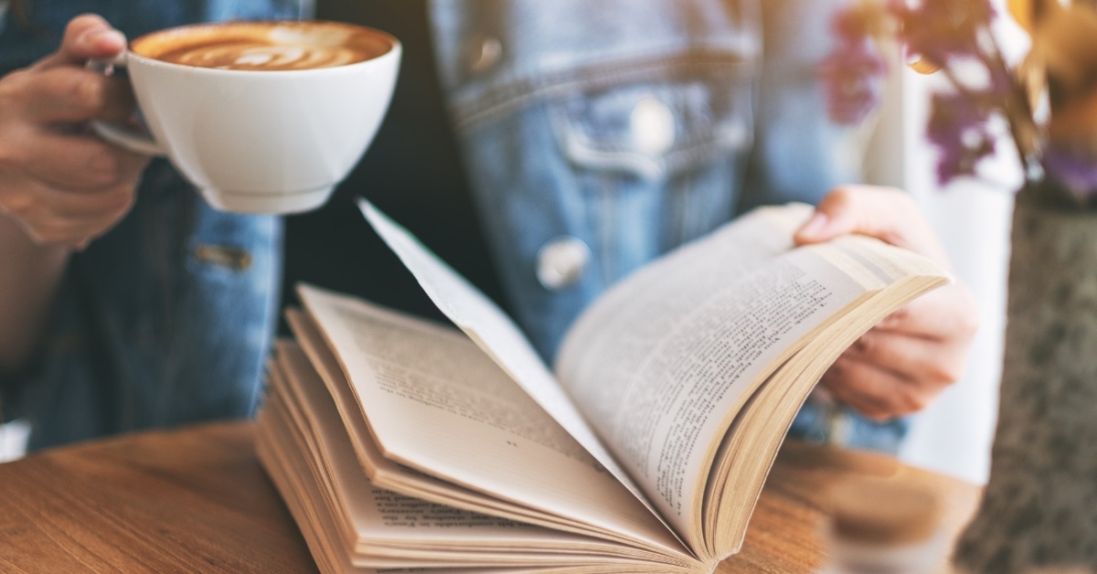 woman reading book while having coffee