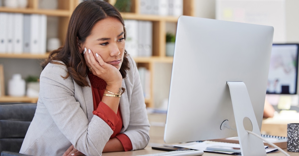 exhausted woman looking at computer screen