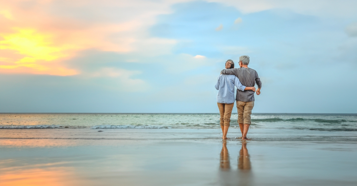 senior couple walking on the beach