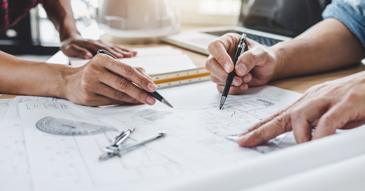 architects and engineers mapping blueprints