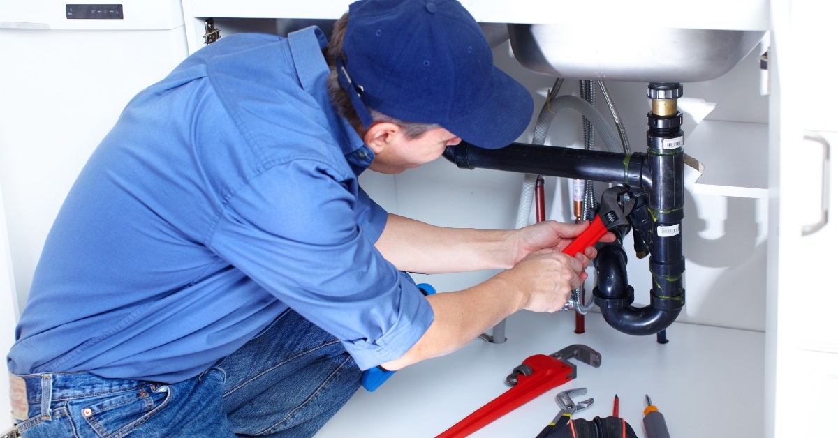 male plumber fixing sink