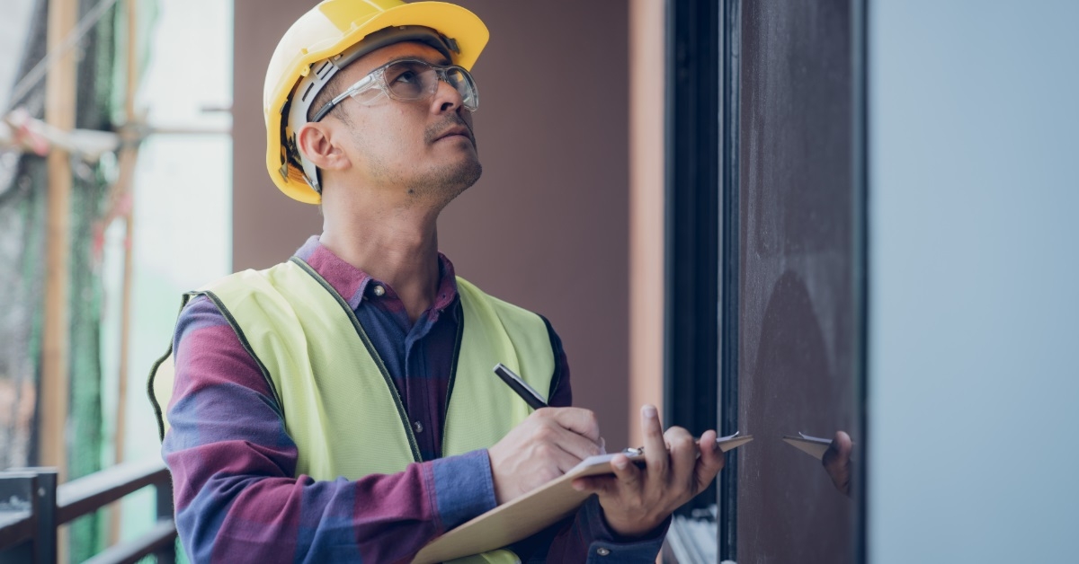 male worker inspecting site with checklist