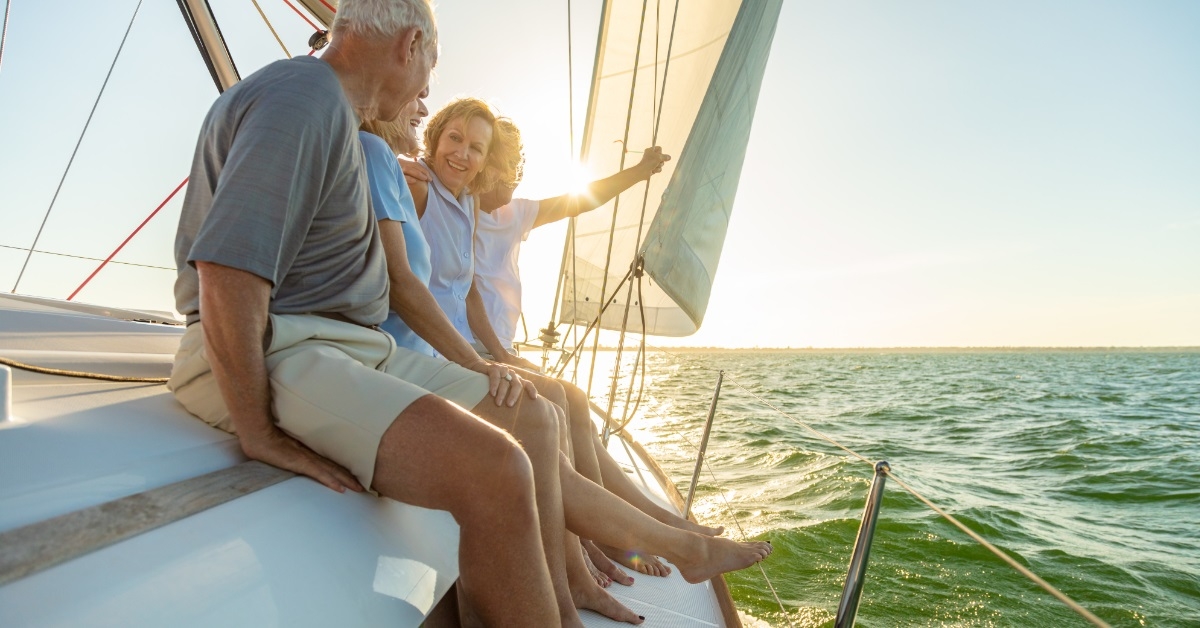 senior friends group sailing luxury yacht