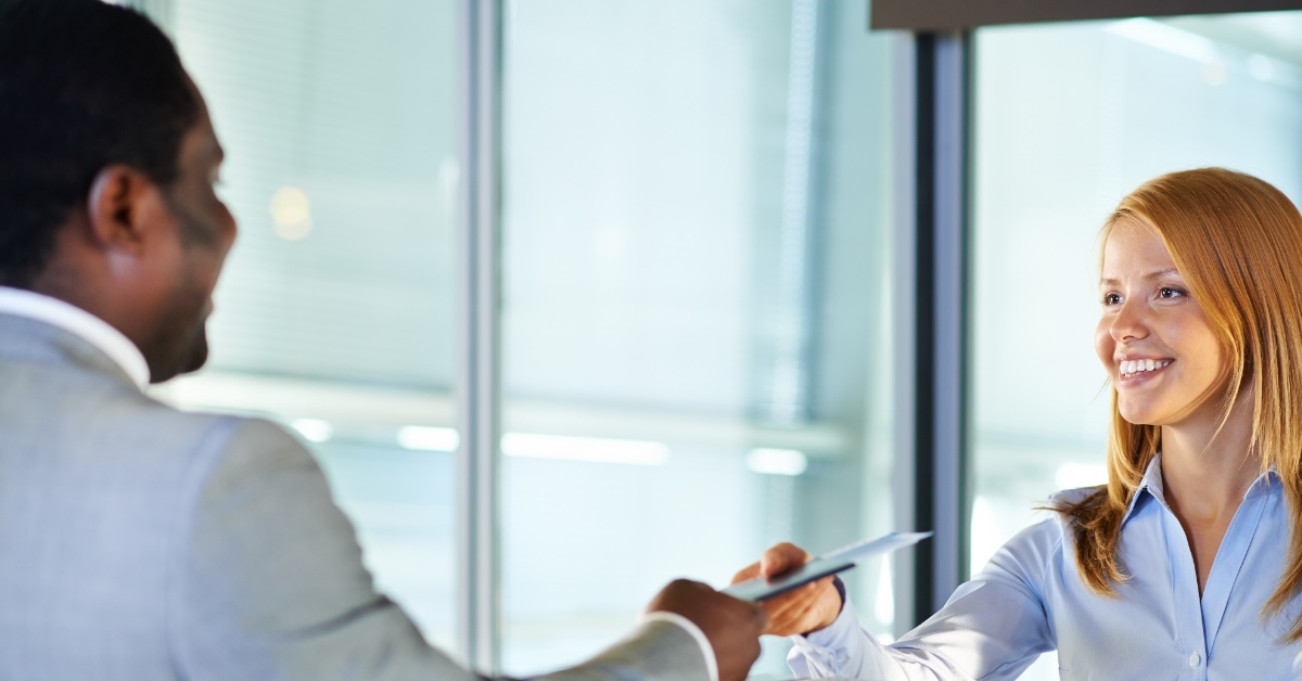 man getting boarding pass from counter