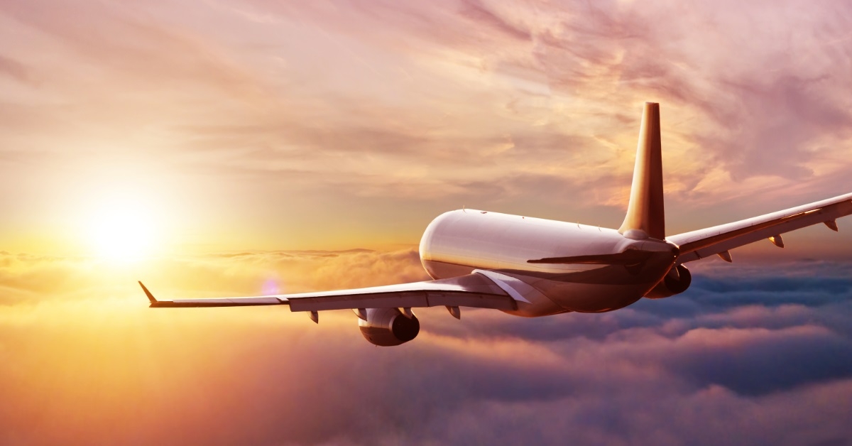 commercial airplane flying above clouds