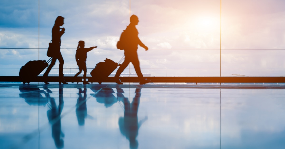 family walking through airport with luggage