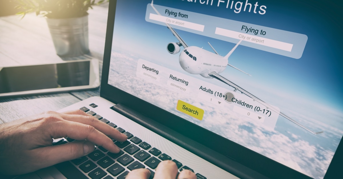man booking flight using laptop