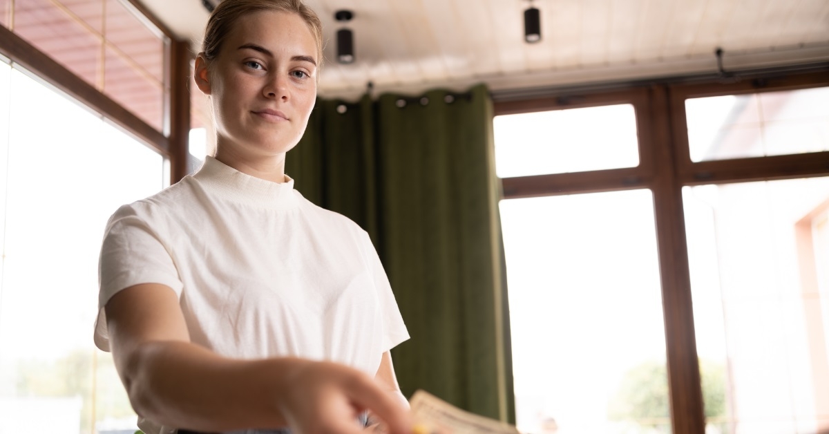 blonde waitress receiving tip from client