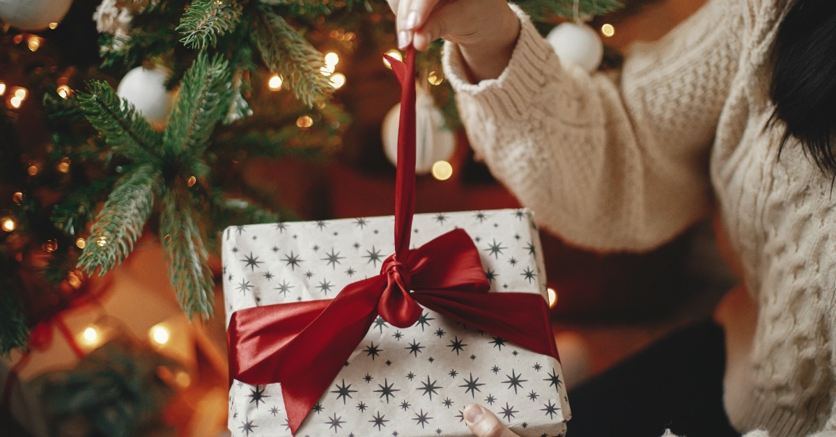 woman opening christmas presnt at home