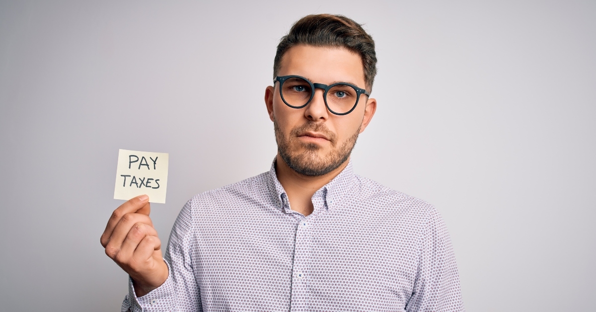 holding pay taxes word on paper