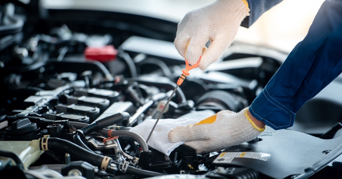 mechanic checking car engine oil