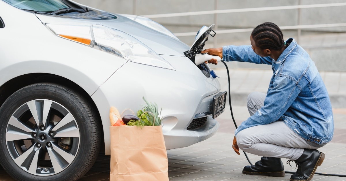 african american man charging electric car