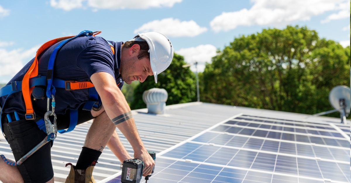 male technician drilling solar pannels
