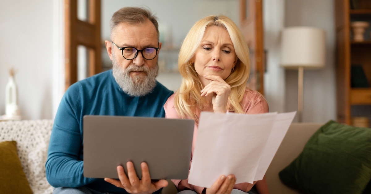 mature spouses reviewing paper bills