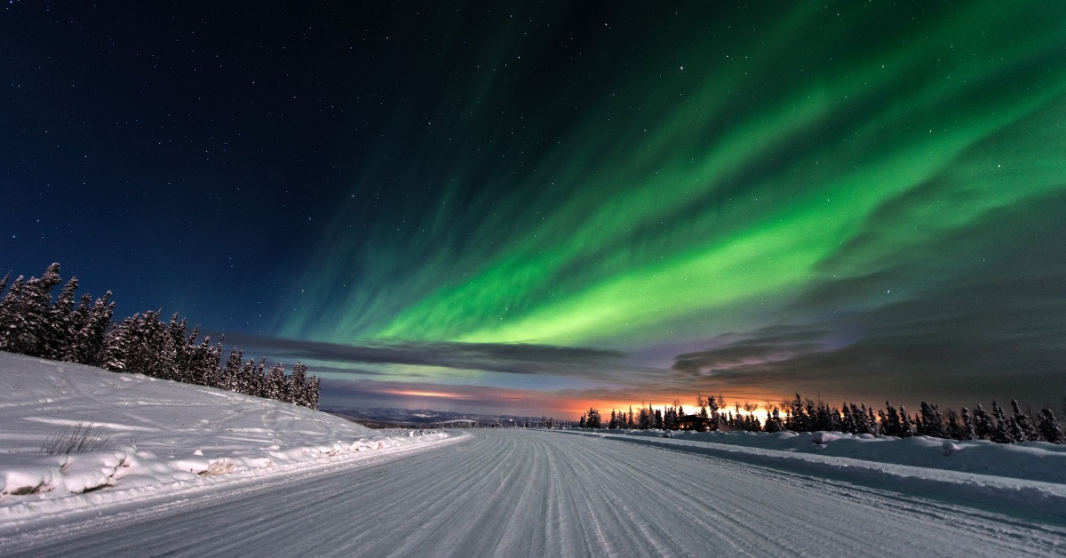 snowy road with aurora lights