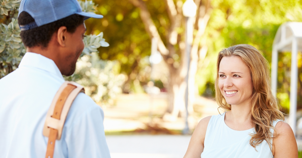 mailman delivering letters to woman