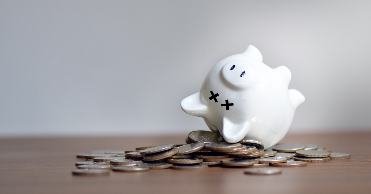 piggy bank lies upside down on coins