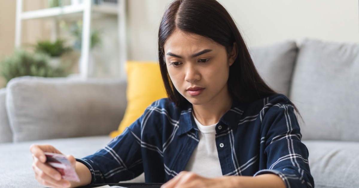 asian woman reviewing bills at home 