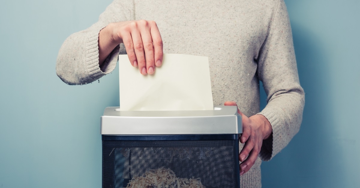 man shredding paper using electric machine