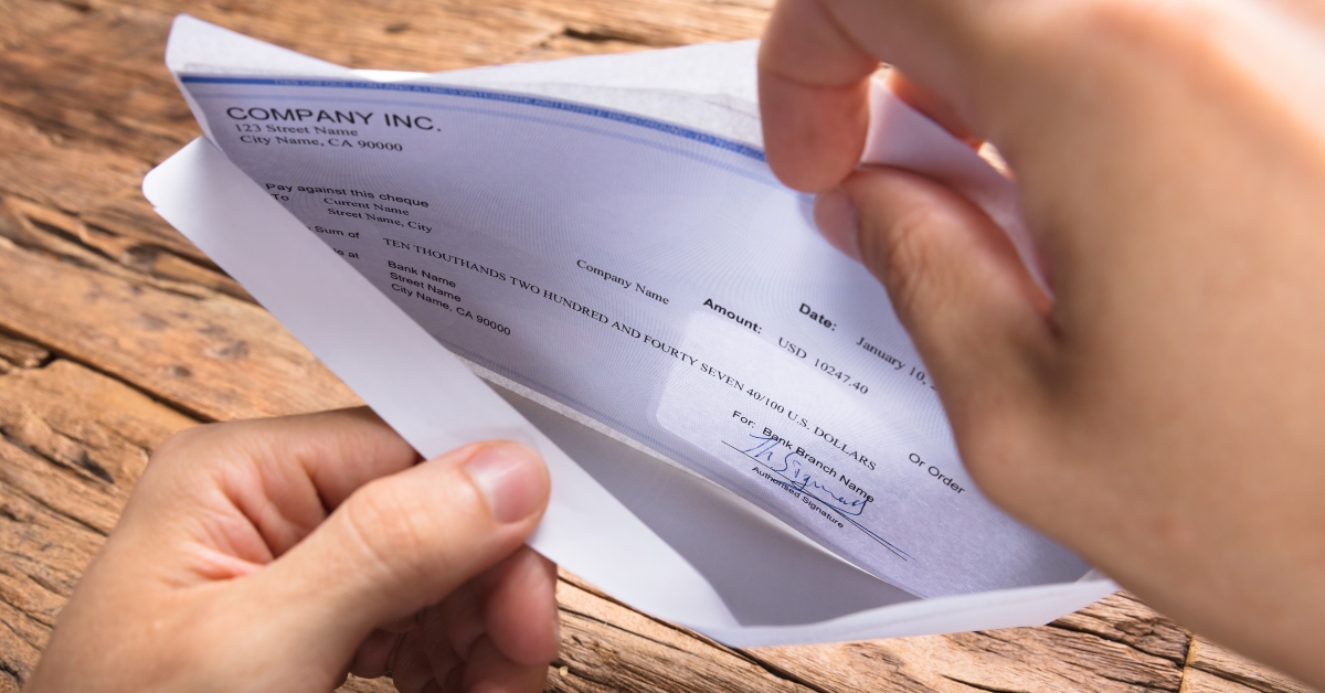 businessman opening envelope with paycheck