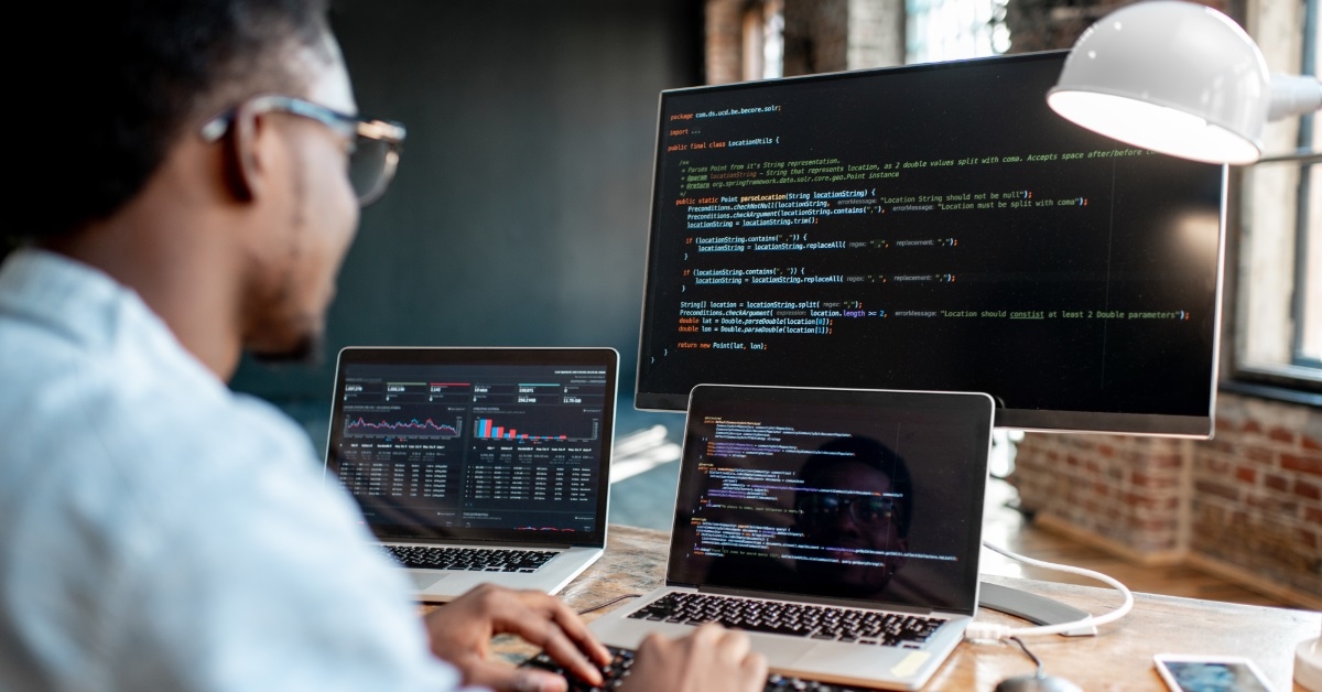 male programmer coding using laptop