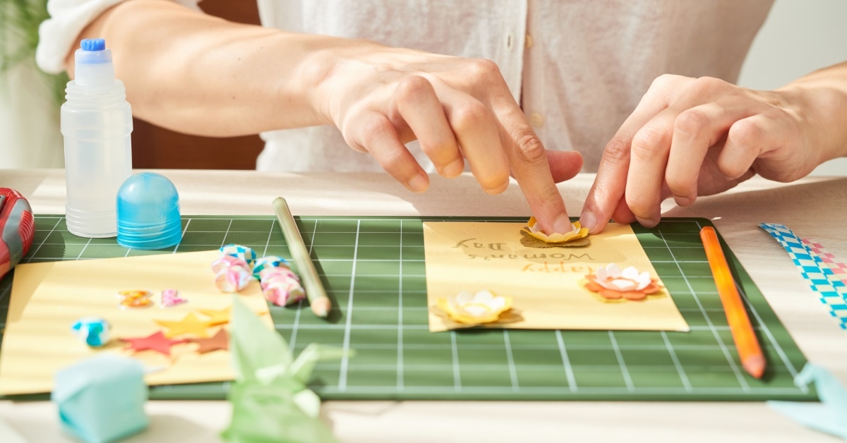 woman decorating greeting card for mother
